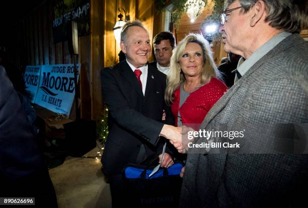 Republican Senate candidate Roy Moore, left, and his wife Kayla leave Moore's "Drain the Swamp" rally in Midland City, Ala., on Monday, Dec. 11, 2017.