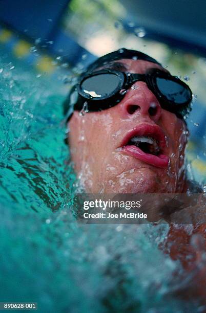 swimmer with cap and goggles, in motion, close-up - swimming stroke stock pictures, royalty-free photos & images