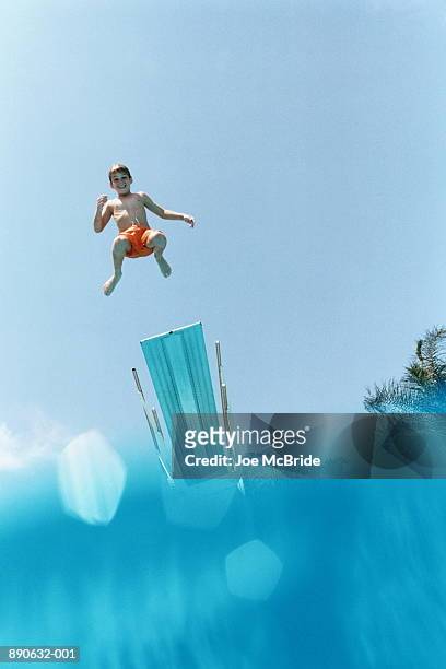 young swimmer (8-10) jumping into pool - low angle view stock pictures, royalty-free photos & images