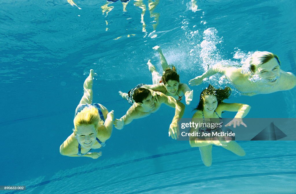 Group of young people in swimming pool, underwater view