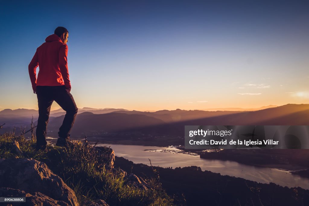 A man at the top of a mountain at sunrise