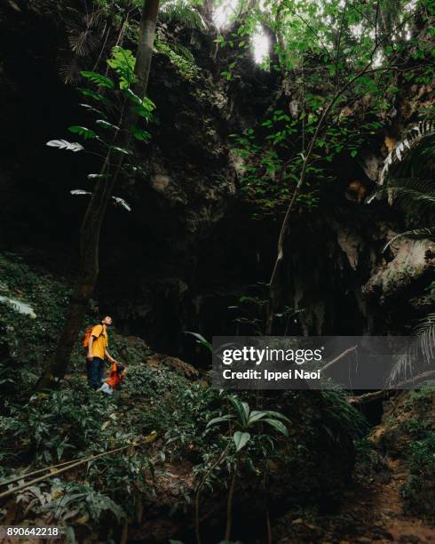 Father and child exploring jungle cave, Iriomote-jima, Japan