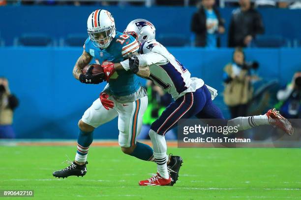 Kenny Stills of the Miami Dolphins tries to avoid the tackle from Malcolm Butler of the New England Patriots during the first quarter at Hard Rock...