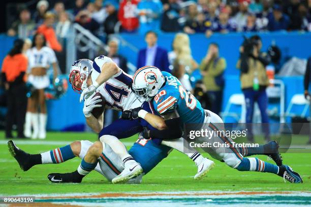 Rex Burkhead of the New England Patriots tries to avoid the tackle from Reshad Jones of the Miami Dolphins during the second quarter at Hard Rock...