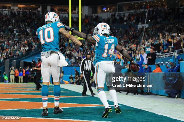 Jarvis Landry celebrates with Kenny Stills of the Miami Dolphins after scoring a touchdown in the second quarter against the New England Patriots at...