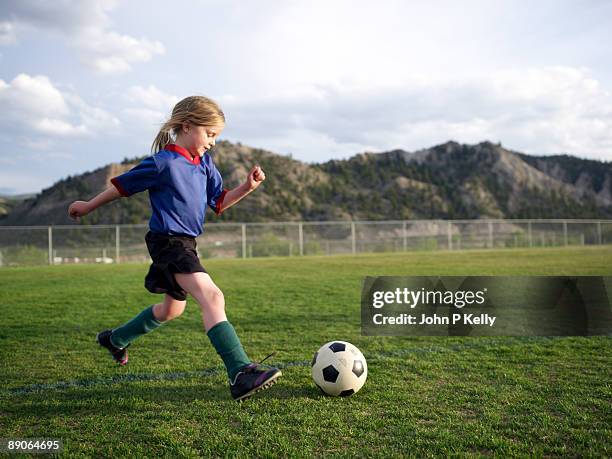 little girl playing soccer - girl mound stock-fotos und bilder