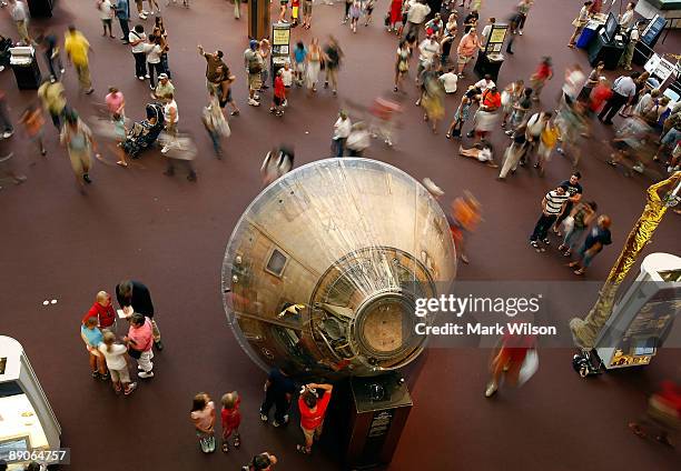 People walk around the Apollo 11 Command Module "Columbia" on display at the National Air and Space Museum on July 16, 2009 in Washington, DC. Forty...