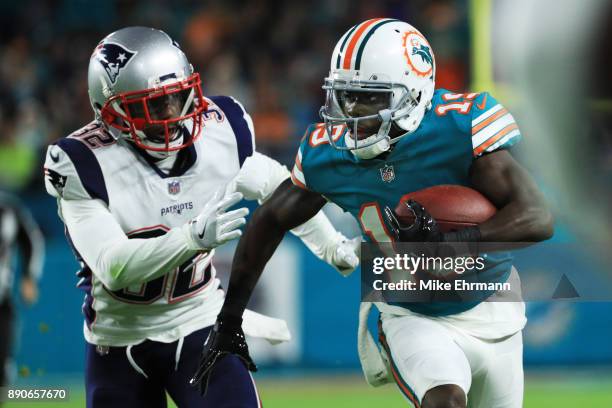 Jakeem Grant of the Miami Dolphins carries the ball against Devin McCourty of the New England Patriots in the second quarter at Hard Rock Stadium on...