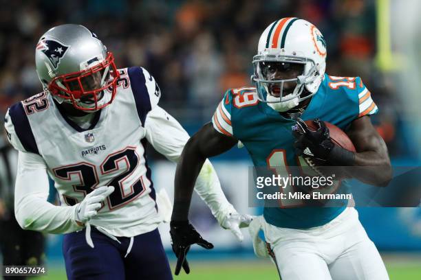 Jakeem Grant of the Miami Dolphins carries the ball against Devin McCourty of the New England Patriots in the second quarter at Hard Rock Stadium on...