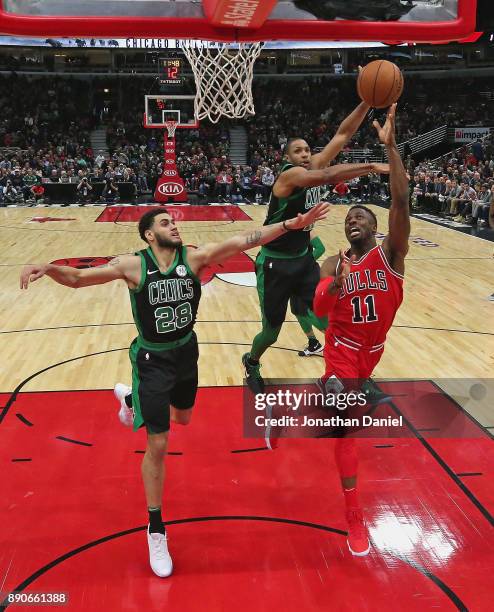 David Nwaba of the Chicago Bulls drievs to the basket against Abdel Nader and Al Horford of the Boston Celtics at the United Center on December 11,...