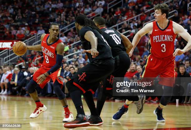 Rajon Rondo of the New Orleans Pelicans dribbles the ball defended by Nene Hilario of the Houston Rockets and Eric Gordon in the second half at...