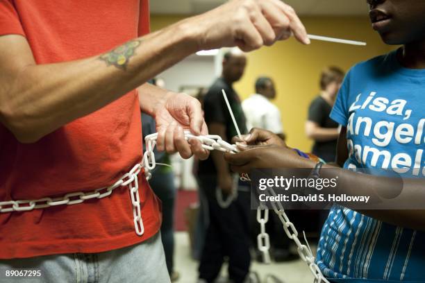 Activists rehearse for their protest in a church space on July 08, 2009 in Washington, DC. The activists plan on chaining themselves together in the...