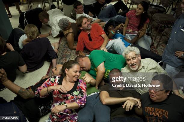 Activists rehearse for their protest in a church space on July 08, 2009 in Washington, DC. The activists plan on chaining themselves together in the...