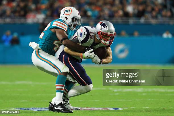 Chris Hogan of the New England Patriots tries to avoid the tackle of Alterraun Verner of the Miami Dolphins in the third quarter at Hard Rock Stadium...