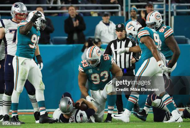 Charles Harris Cameron Wake and Ndamukong Suh of the Miami Dolphins celebrate sacking Tom Brady of the New England Patriots in the fourth quarter at...