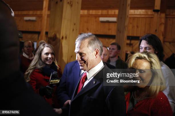 Roy Moore, Republican candidate for U.S. Senate from Alabama, center, and his wife Kayla Moore, right, leave a campaign rally in Midland City,...
