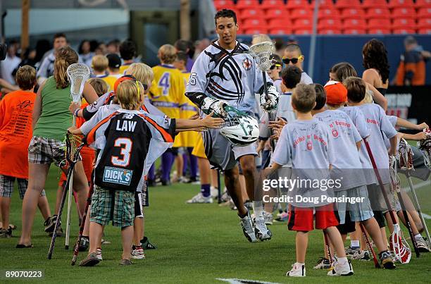 Ricky Pages of the Long Island Lizards and playing for the Young Guns is welcomed to the field by youth lacrosse players during player introductions...