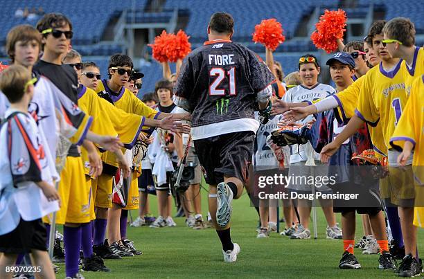 Chris Fiore of the Long Island Lizards and playing for the Old School is welcomed to the field by youth lacrosse players during player introductions...