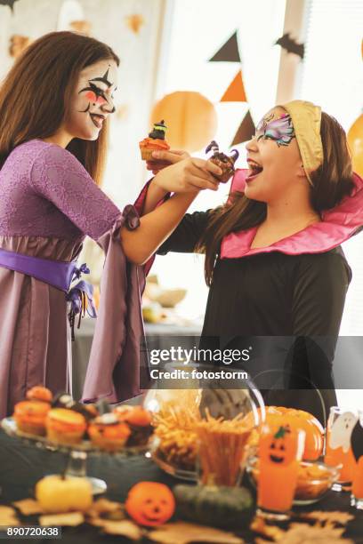 girls eating cupcakes - halloween party stock pictures, royalty-free photos & images