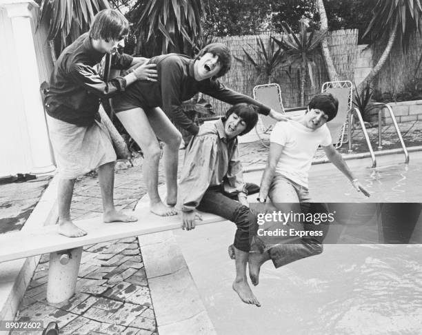 British pop group The Beatles clown about on the diving board of their Hollywood Hills hideout during their tour of Canada and the US, 28th August...