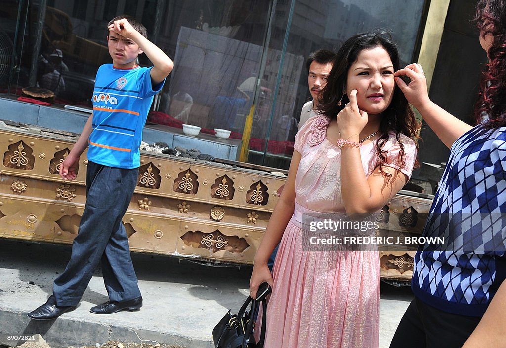 A Uighur woman touches her daughter's fa