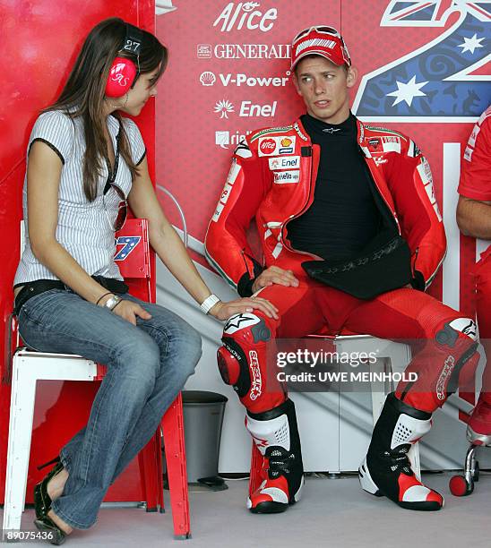 Australian Ducati driver Casey Stoner sits next to his wife Adriana in his box on the sidelines of the MotoGP race training session of the German...