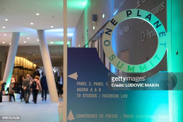 Sign shows access to panel and conference rooms at the start of the One Planet Summit on December 12, 2017 at La Seine Musicale venue on l'ile Seguin...