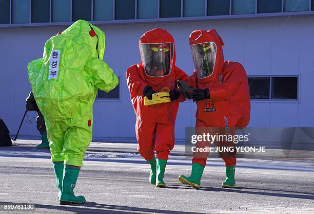 South Korean rescue members wearing chemical protective suits take part in an anti-terror drill at the Olympic Stadium, the venue of the opening and...