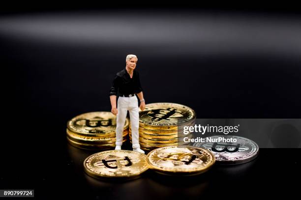 Miniature figures near Bitcoin physical coin. Futures on Bitcoins increased by more than 20% after their American debut on the Chicago Cboe Futures...
