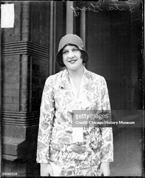 Informal three-quarter length portrait of Mrs. Lita Grey Chaplin looking to her right, standing in front of a building in a room in Chicago,...