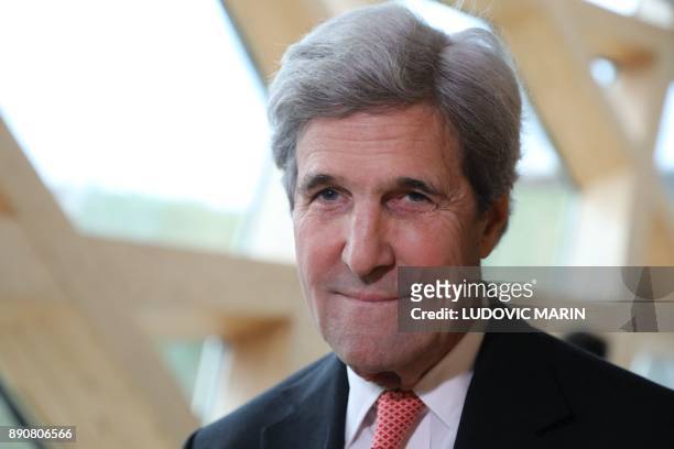 Former US secretary of state John Kerry smiles during the One Planet Summit on December 12, 2017 at La Seine Musicale venue on l'ile Seguin in...