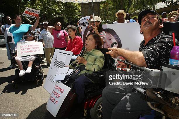 Lillibeth Navarro and Cynde Soto protest against cuts to social services that aid people with disabilities and the poor at the home of California...