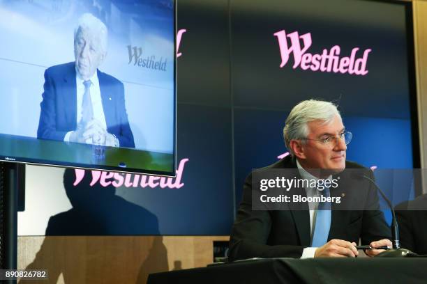 Steven Lowy, co-chief executive officer of Westfield Corp., sits as billionaire Frank Lowy, chairman, is seen on a screen during a news conference in...