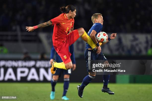 Yosuke Ideguchi of Japan and Zhao Yuhao of China compete for the ball during the EAFF E-1 Men's Football Championship between Japan and China at...