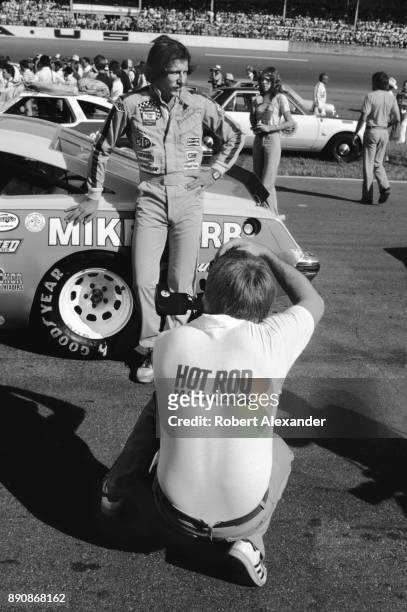 Photographer for Hot Rod Magazine takes a picture of NASCAR driver Dale Earnhardt Sr. Prior to the start of the 1980 Firecracker 400 NASCAR race at...