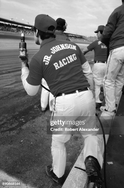 Crew members of the Junior Johnson Racing team snap into action as the team's driver, Cale Yarborough, comes in for a pit stop during the running of...