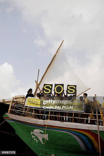 Indian children, representing a non-governmental organisation and residing at a low-lying area of Mumbai, demonstrate with a banner on a boat at the...