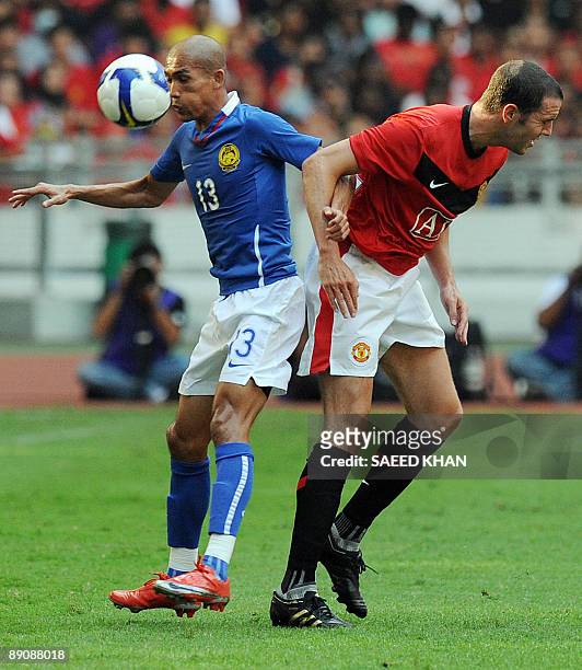 John O'Shea of Manchester United vies with Malaysian forward Indra Putra Mahayuddin at the National Stadium in Kuala Lumpur on July 18, 2009....