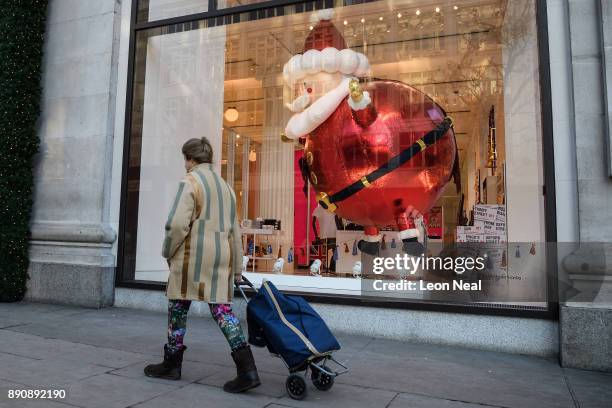 Christmas shoppers walk past festive window displays on Oxford Street on December 12, 2017 in London, England. Inflation has risen to 3.1% in...