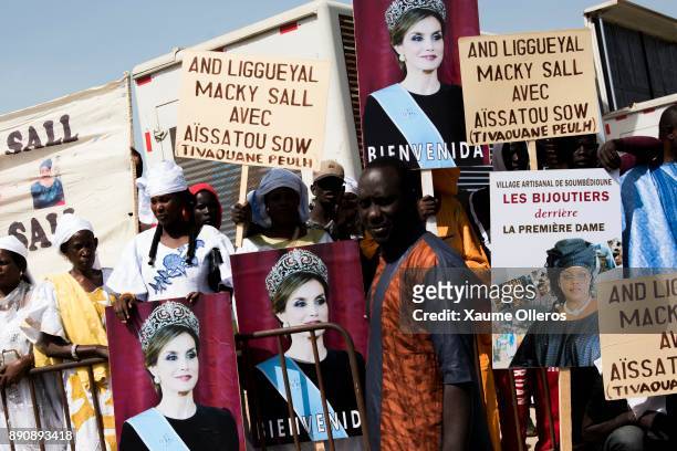 Women hold Queen Letizia of Spain banners prior to her arrival to a lunch offered by first lady Marieme Faye Sall on December 12, 2017 in Dakar,...
