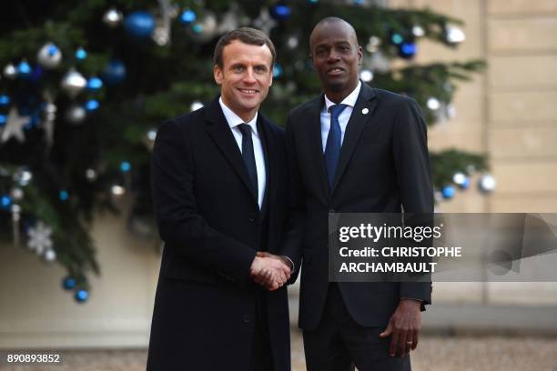 French President Emmanuel Macron greets Haitian President Jovenel Moise as he arrives at the Elysee palace on December 12, 2017 in Paris, for a lunch...