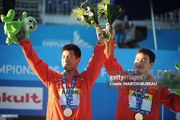 The diving pair Chinese Qin Kai and Wang Feng celebrate their gold medal on the podium of the diving Men's 3m springboard synchronised final on July...