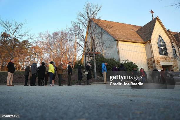 Voters wait in line to cast their ballot at a polling station setup in the St Thomas Episcopal Church on December 12, 2017 in Birmingham, Alabama....