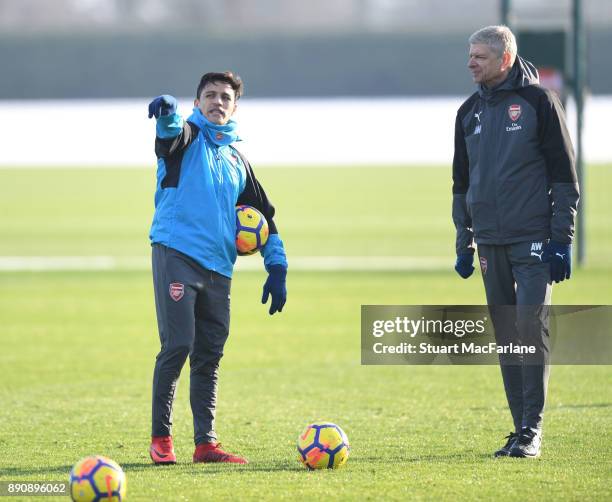 Arsenal manager Arsene Wenger with Alexis Sanchez during a training session at London Colney on December 12, 2017 in St Albans, England.