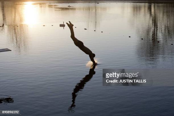 Swimmer dives into the ice cold water at Highgate Men's Bathing Pond, in north London on December 12 at sunrise on a freezing winter morning.