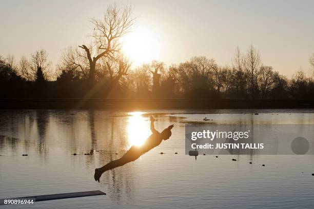 Swimmer dives into the ice cold water at the Highgate Men's Bathing Pond in north London on December 12 at sunrise on a freezing winter morning. /...