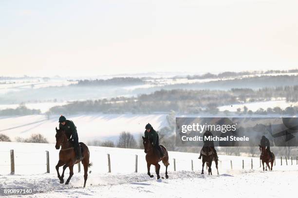 Racehorses workout in heavy snow during the morning gallops at the yard of national hunt trainer Nigel Twiston-Davies on December 12, 2017 in...