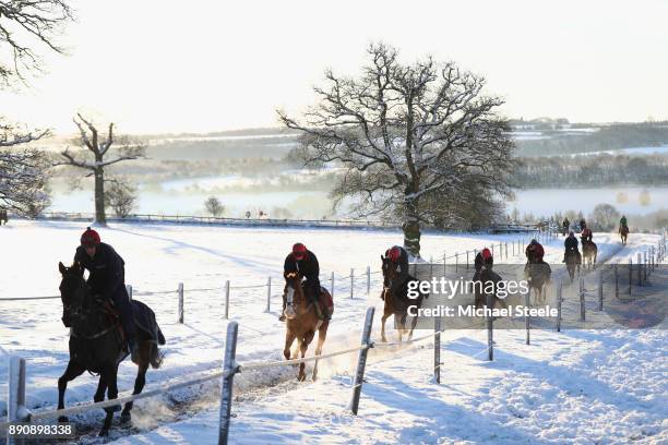 Racehorses workout in heavy snow during the morning gallops at the yard of national hunt trainer Nigel Twiston-Davies on December 12, 2017 in...