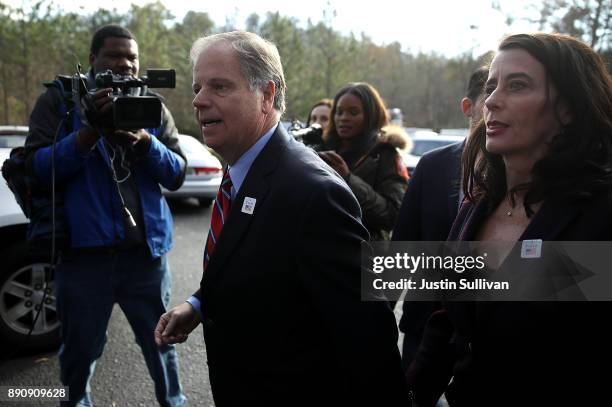 Democratic senatorial candidate Doug Jones walks with his wife Louise Jones after voting at Brookwood Baptist Church on December 12, 2017 in Mountain...