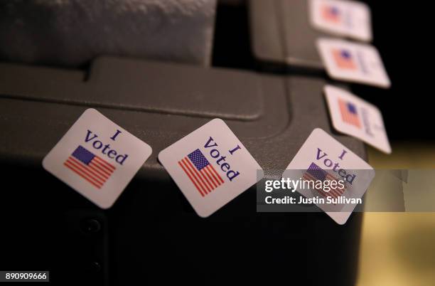 Voted stickers are displayed on a voting machine as democratic senatorial candidate Doug Jones casts his ballot at Brookwood Baptist Church on...